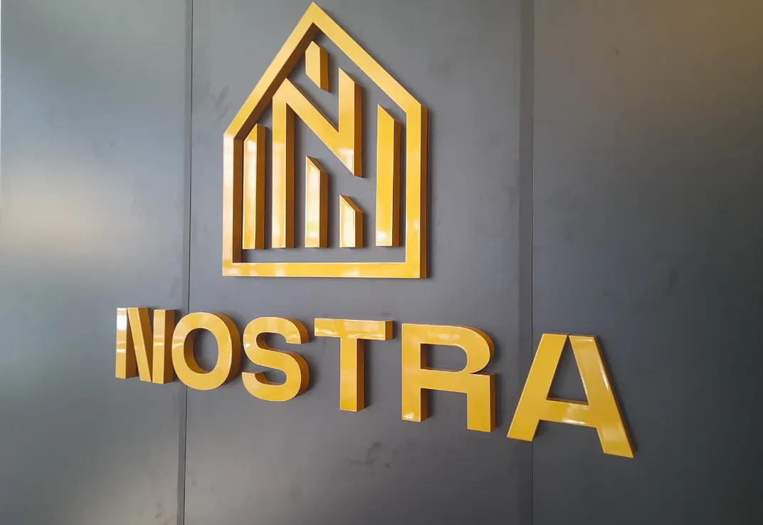 Letreiro da Nostra em letras-caixa douradas